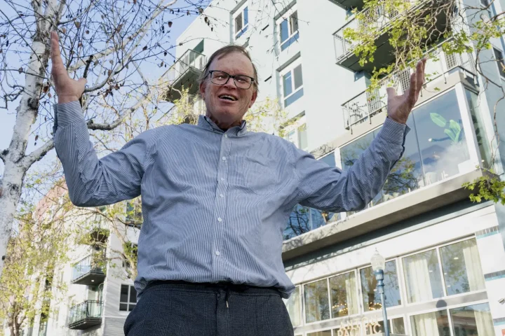 Mayoral candidate Chris Krohn in front of new high rise apartments